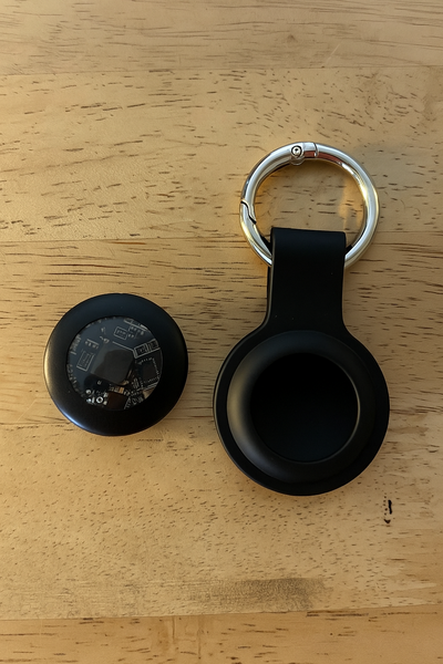 Black Geo Tagr device and keychain on a wooden surface