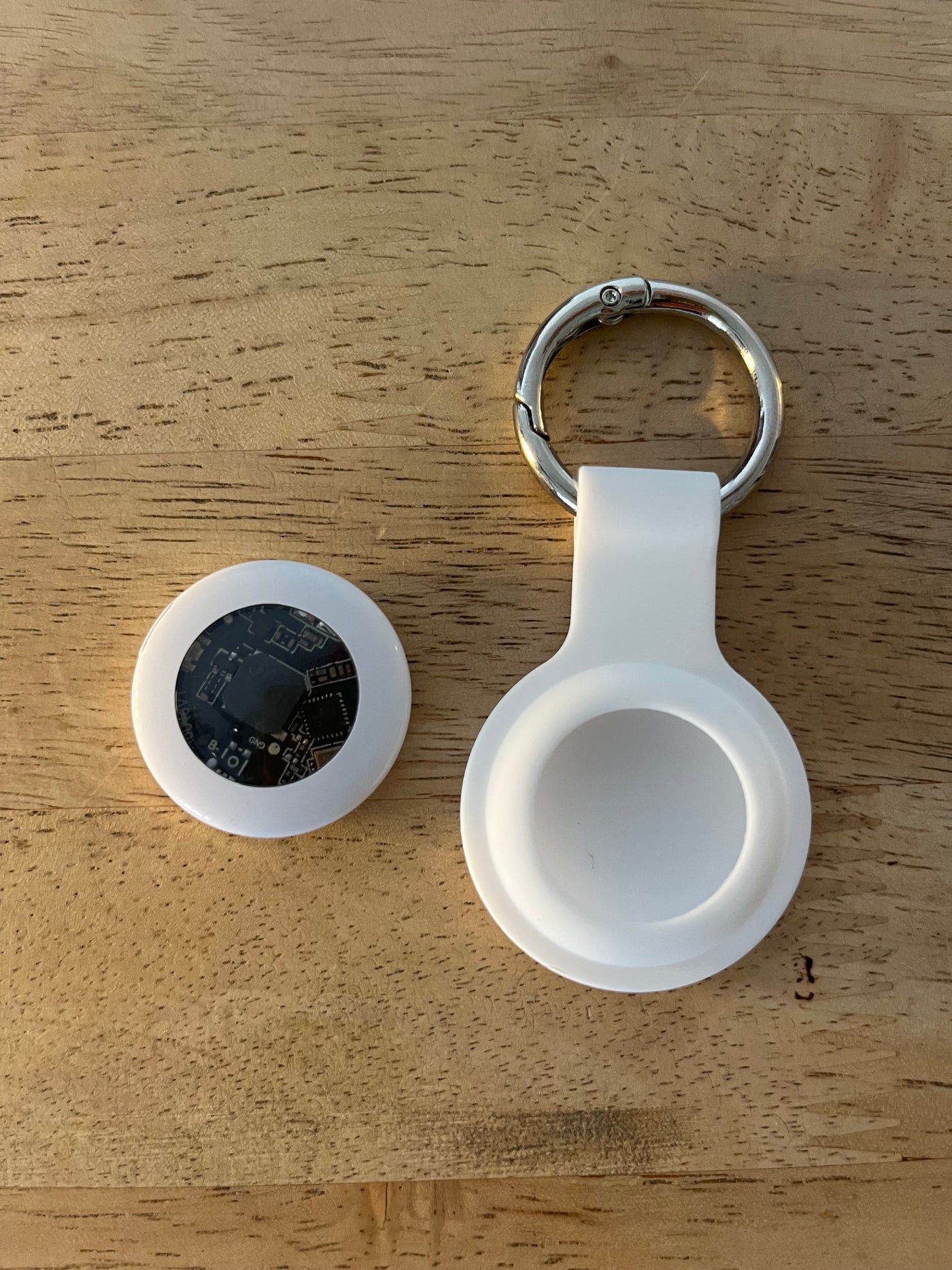 White Geo Tagr with keychain on a wooden surface